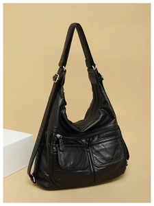 Detail of black pebbled leather hobo bag with multi-pockets and silver metal hardware