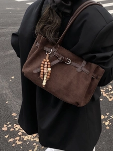 Deep brown matte tote bag with wooden bead charm and minimalist vintage strap detail