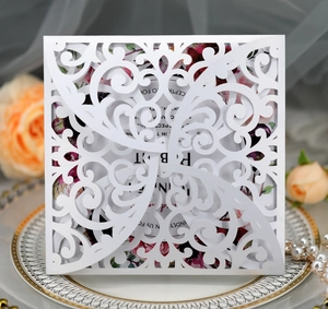 Detail of laser-cut vine patterns on pearl white wedding invitation with floral insert