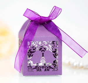 Close-up of purple laser-cut candy box with bell patterns and a satin ribbon bow