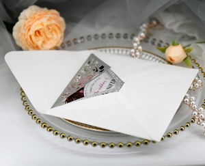 Close-up of laser-cut glitter wedding invitation with rose insert and elegant pearl decor