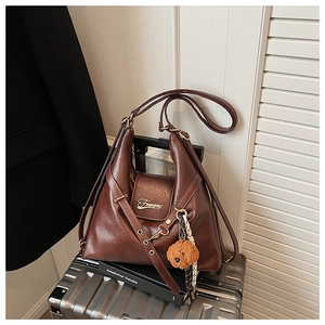 Détail du sac fourre-tout marron vintage sur valise avec porte-clés chien en peluche