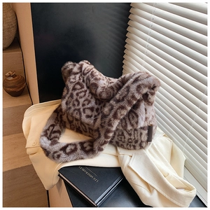 Dettaglio della borsa a tracolla in pelliccia sintetica leopardata su un blazer beige