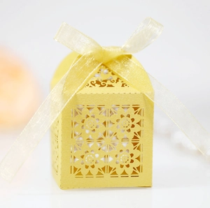 Close-up of bright yellow laser-cut candy box with floral patterns and matching ribbon