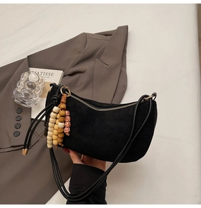 Detail of black frosted crescent bag featuring creative multi-color wooden bead charm