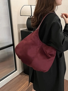 Vintage burgundy tote bag with wide shoulder strap shown in a minimalist home setting