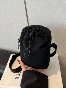 Waterproof black nylon crossbody phone bag with drawstring pocket and wide strap