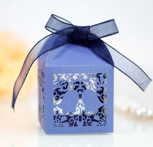 Navy blue laser-cut Christmas candy box with hollow snowflake pattern and ribbon