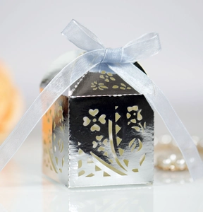 Detail of silver laser-cut candy box with floral patterns and a light blue ribbon bow