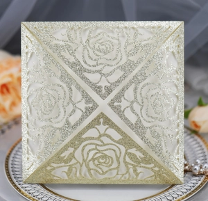 Detailed laser cut rose patterns on champagne gold glitter wedding invitation card