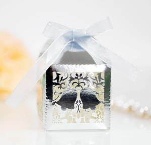 Laser-cut silver hollow snowflake bell candy box with a light blue ribbon bow for gifts