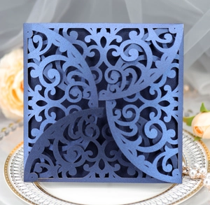 Detail of laser-cut navy blue wedding invitation with intricate floral lace pattern