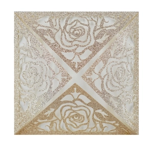 Detailed laser-cut champagne gold glitter paper invitation with intricate rose flower patterns
