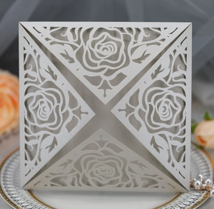 Close-up of silver laser-cut rose hollow invitation card on decorative plate