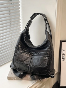 Black leather-textured multi-functional bag with silver zippers for travel or commute