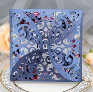 Detail showing laser-cut navy blue wedding invitation with elegant floral inner card