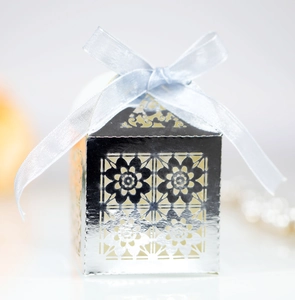 Laser-cut silver favor box with floral patterns and a soft light blue satin ribbon bow