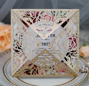 Macro view of gold glitter laser-cut rose cover and watercolor floral wedding invite card