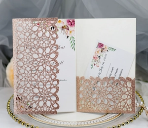 Close-up of rose gold glitter laser-cut floral wedding invitation with inner cards