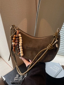 Deep brown matte suede crescent shoulder bag with knotted strap and beaded tassel detail