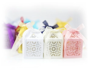 Detailed macro view of festive laser-cut floral candy boxes with elegant satin bows