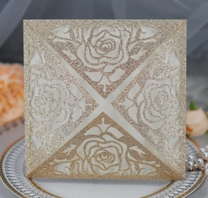 Detail of champagne gold glitter laser cut invitation cover with elegant rose patterns