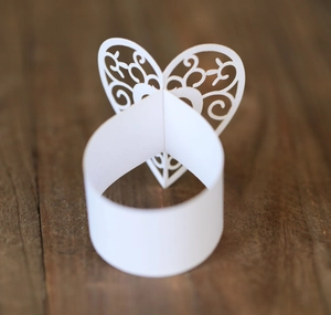 Détail du motif de cœur découpé au laser sur le rond de serviette en papier perlé blanc