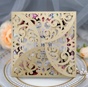 Detail of laser cut gold glitter wedding invitation with floral inner card and lace patterns