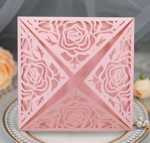 Detail view of pink laser-cut rose hollow invitation on white ceramic plate with pearls