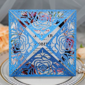 Detail of blue glitter laser-cut rose wedding invitation with elegant floral hollow design