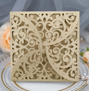 Detailed laser-cut gold wedding invitation featuring elegant floral vine hollow patterns