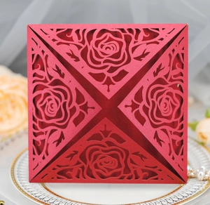 Macro shot of laser-cut rose patterns on square red pearlescent cardstock invitation