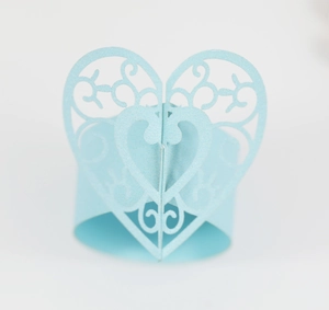 Détail macro du rond de serviette en papier nacré bleu clair avec motif cœur découpé