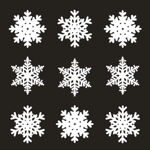 Nine diverse white snowflake laser-cut cards with geometric patterns on a black background