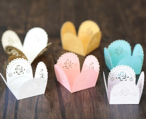Macro view of laser-cut paper wrappers for chocolates with elegant floral patterns