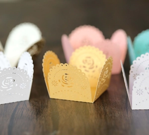 Detail of laser-cut rose floral cupcake wrappers in various pastel macaron colors