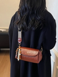 Vintage brown leather crossbody bag with ethnic patterned strap and wooden beads