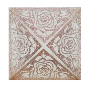 Macro detail of laser-cut rose floral pattern on glitter rose gold wedding invitation card