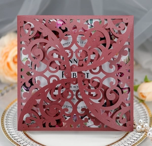 Intricate laser-cut burgundy wedding invitation card with floral insert and scrollwork