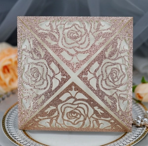Detailed laser-cut rose patterns on rose gold glitter wedding invitation card set