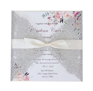 Laser cut glitter wedding invitation with silver lace cover and cream ribbon bow