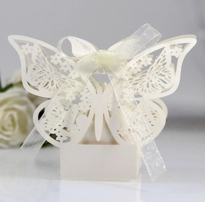 Detail of laser-cut white butterfly candy box with floral patterns and a silk ribbon bow