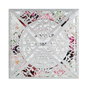 Macro detail of laser-cut silver glitter wedding invitation with floral insert