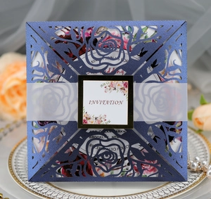 Detail of laser-cut rose floral wedding invitation in navy blue pearlescent paper