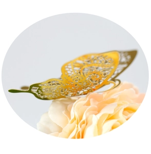 Macro shot of gold hollow butterfly with intricate lace patterns on a soft faux flower
