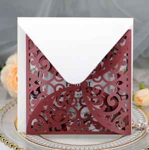 Detailed laser-cut burgundy invitation card with elegant floral lace and ivory envelope