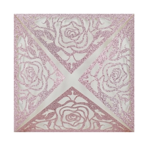 Close-up of laser-cut glitter pink invitation cover with intricate rose floral patterns