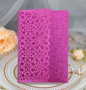 Detailed laser-cut magenta glitter invitation card with floral mandala patterns on porcelain