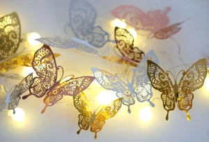 Macro shot of 3D hollow butterfly LED fairy lights with gold and silver lace patterns