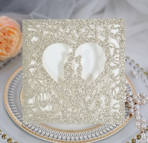Détail de l'invitation de mariage découpée au laser pailletée champagne avec cœur